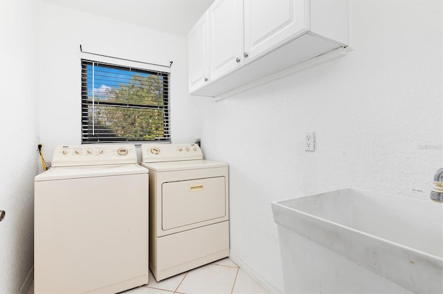 washroom featuring cabinets, light tile patterned floors, sink, and washing machine and dryer