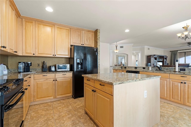 kitchen featuring a center island, sink, decorative light fixtures, light brown cabinetry, and black appliances