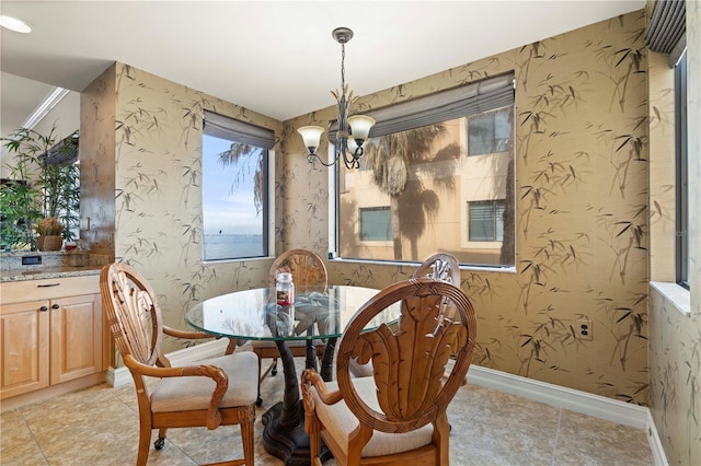 dining space featuring a notable chandelier and a water view