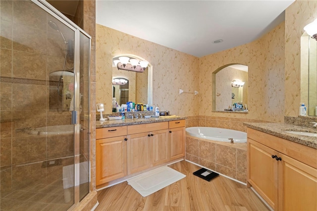 bathroom featuring hardwood / wood-style floors, vanity, and shower with separate bathtub