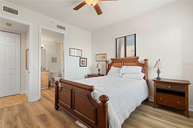 bedroom featuring a closet, ensuite bathroom, light hardwood / wood-style flooring, and ceiling fan