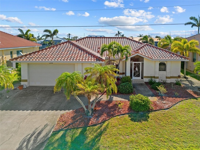 mediterranean / spanish-style house featuring a garage and a front lawn