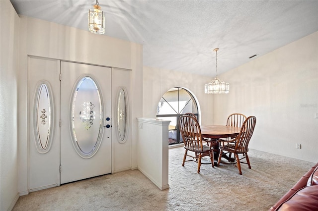 entrance foyer with light colored carpet, washer / clothes dryer, and a chandelier