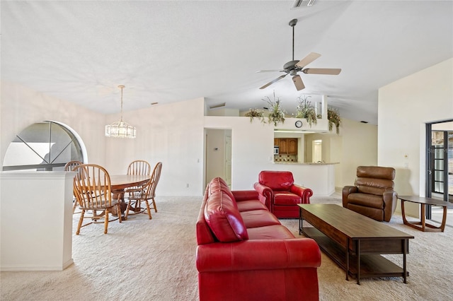 living room with ceiling fan with notable chandelier, light colored carpet, and vaulted ceiling