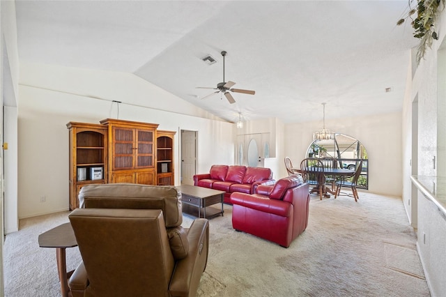 carpeted living room featuring ceiling fan with notable chandelier and high vaulted ceiling