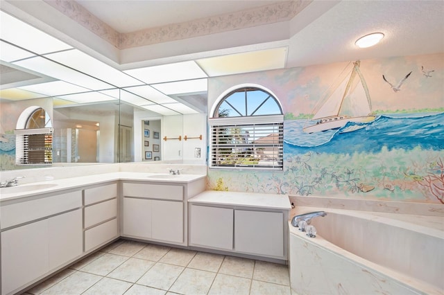 bathroom with a washtub, vanity, and tile patterned floors