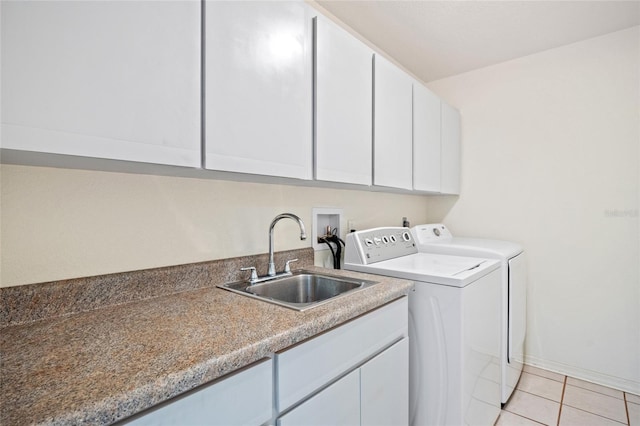 laundry room with washing machine and clothes dryer, sink, light tile patterned flooring, and cabinets