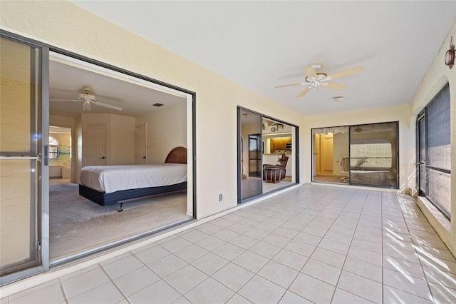 unfurnished sunroom with ceiling fan