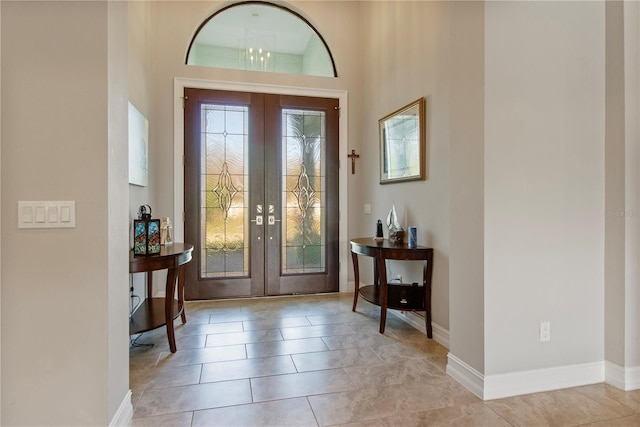 tiled foyer with a high ceiling and french doors