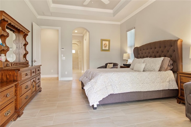 bedroom featuring connected bathroom, a tray ceiling, ceiling fan, and ornamental molding