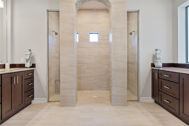 bathroom with tiled shower, vanity, and tile patterned flooring