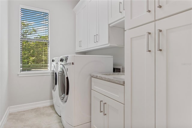 washroom featuring a healthy amount of sunlight, cabinets, and separate washer and dryer