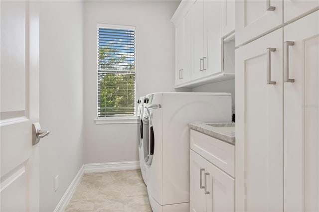 washroom with plenty of natural light, cabinets, and washing machine and clothes dryer