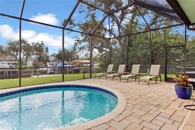 view of swimming pool with a lanai, a patio area, and a yard