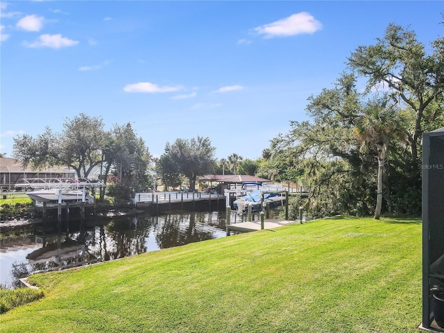 dock area featuring a lawn and a water view