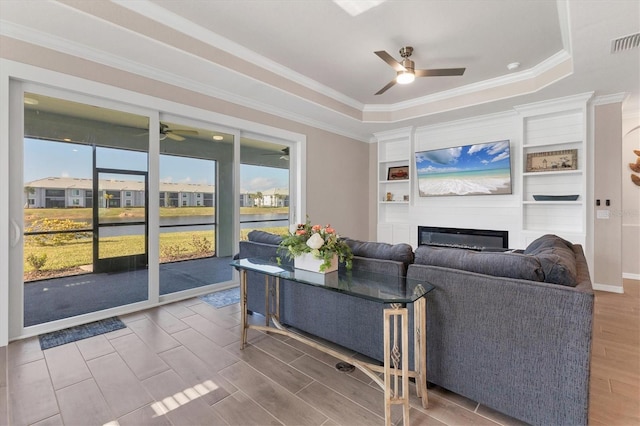 living room featuring plenty of natural light, a fireplace, and crown molding