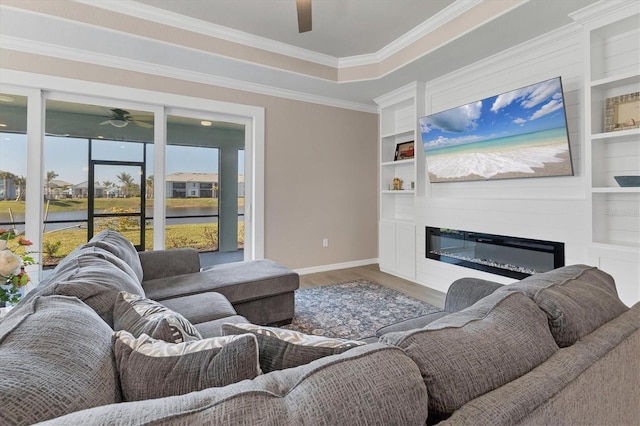 living room with a raised ceiling, built in features, wood-type flooring, and ornamental molding