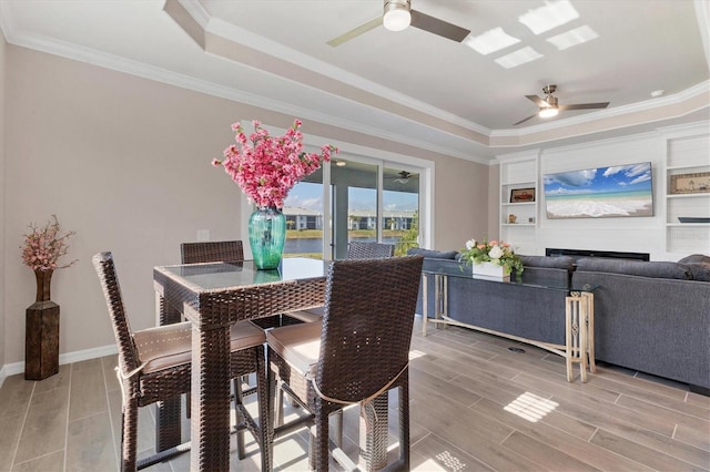 dining room featuring a raised ceiling, ceiling fan, and crown molding