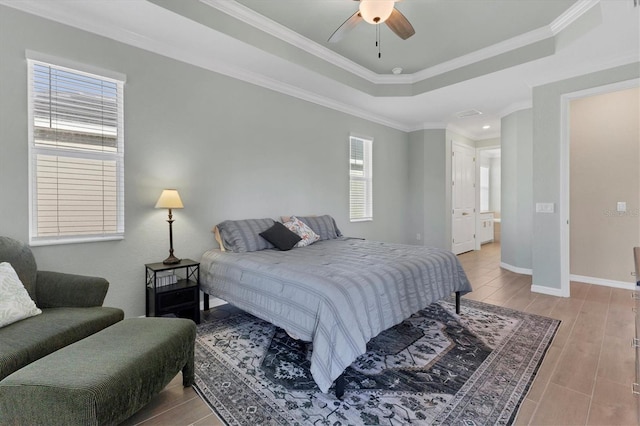 bedroom with ceiling fan, a raised ceiling, and ornamental molding