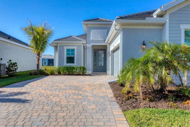 property entrance with a garage and central air condition unit