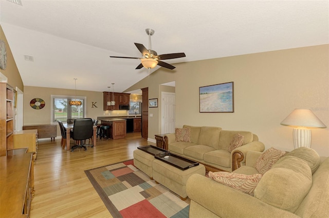 living room with ceiling fan, light hardwood / wood-style floors, and lofted ceiling