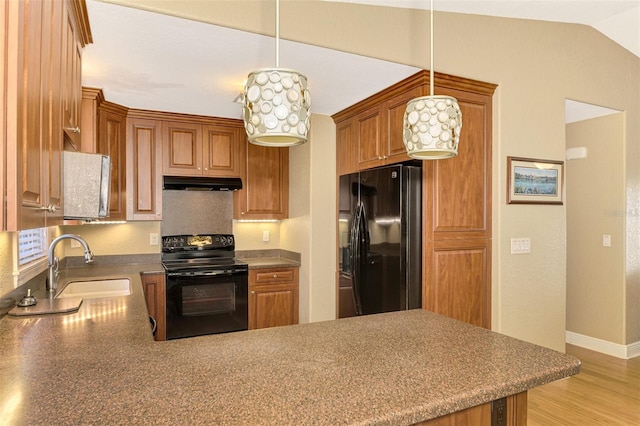 kitchen featuring kitchen peninsula, pendant lighting, black appliances, and sink