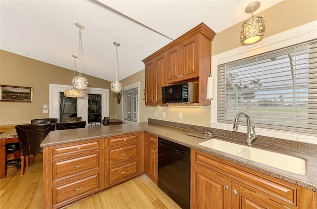 kitchen featuring sink, kitchen peninsula, pendant lighting, lofted ceiling, and black appliances