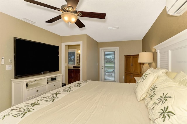 bedroom with connected bathroom, ceiling fan, and a wall mounted air conditioner