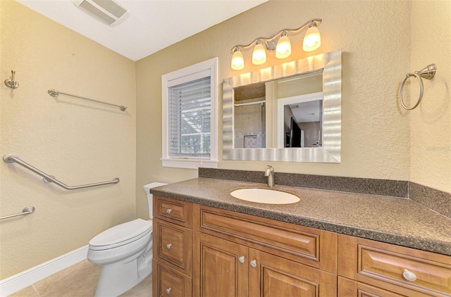 bathroom featuring tile patterned floors, vanity, a shower with shower door, and toilet