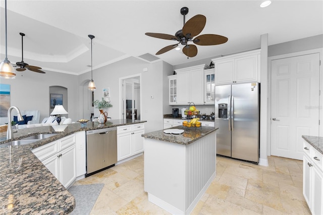 kitchen featuring stainless steel appliances, sink, white cabinetry, a center island, and a raised ceiling