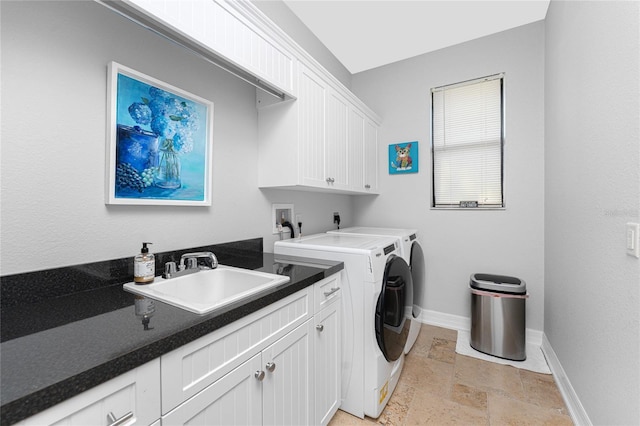 washroom featuring cabinets, washer and clothes dryer, and sink