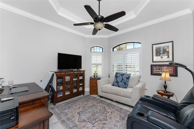 living room with ceiling fan, a tray ceiling, and crown molding