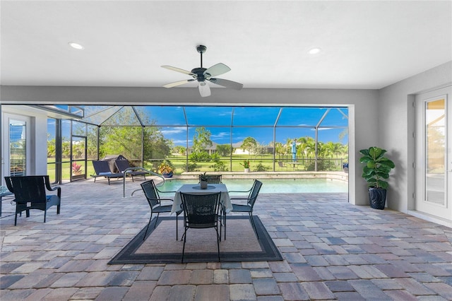 view of patio with ceiling fan and glass enclosure