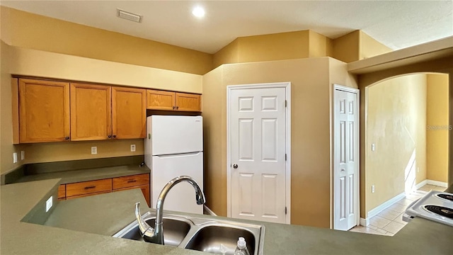 kitchen featuring sink, white fridge, and light tile patterned floors