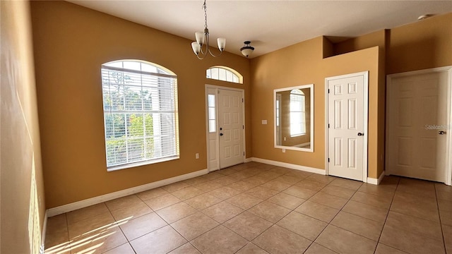 foyer featuring tile patterned floors, a wealth of natural light, and a chandelier