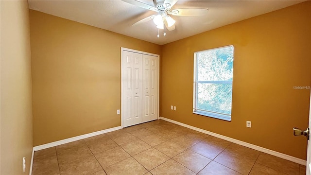 unfurnished bedroom featuring ceiling fan, a closet, and light tile patterned flooring