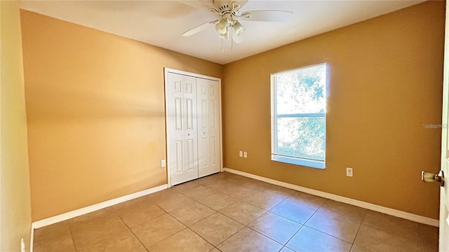 unfurnished bedroom with ceiling fan, a closet, and light tile patterned floors