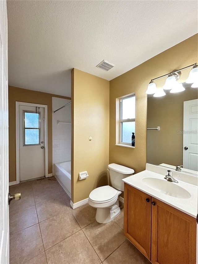 bathroom featuring toilet, a textured ceiling, vanity, and tile patterned floors