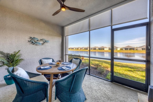 sunroom / solarium featuring a water view, ceiling fan, and a healthy amount of sunlight