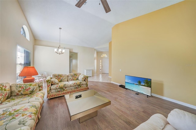 living room featuring hardwood / wood-style floors, ceiling fan with notable chandelier, and lofted ceiling