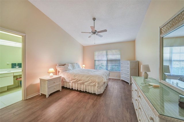 bedroom featuring ensuite bath, vaulted ceiling, ceiling fan, and dark wood-type flooring