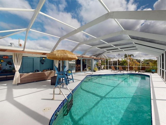 view of swimming pool featuring a patio area and a lanai