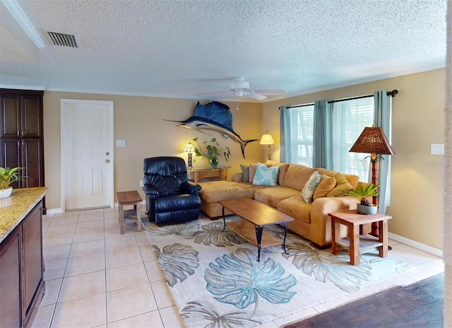 living room with a textured ceiling, ceiling fan, ornamental molding, and light tile patterned flooring