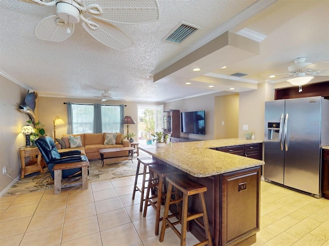 kitchen with stainless steel fridge with ice dispenser, kitchen peninsula, crown molding, a textured ceiling, and a breakfast bar