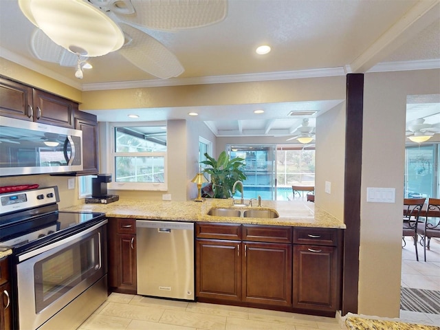 kitchen featuring appliances with stainless steel finishes, ceiling fan, crown molding, and sink