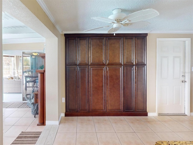 interior space featuring a textured ceiling, ceiling fan, and crown molding