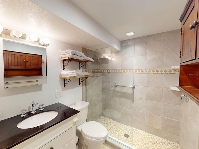 bathroom featuring toilet, vanity, and tiled shower