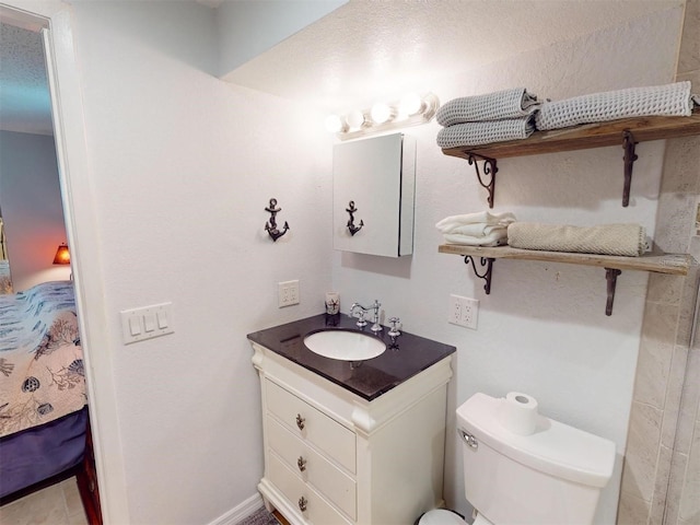 bathroom with vanity, toilet, and a textured ceiling