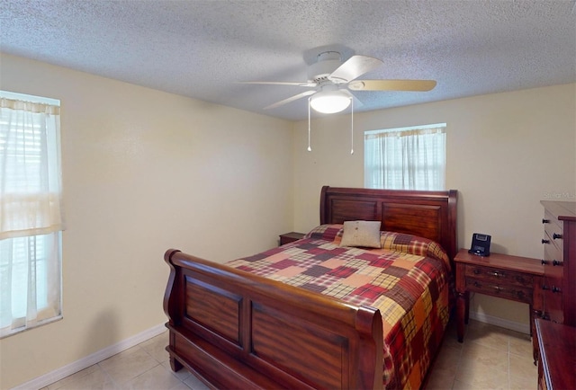 tiled bedroom featuring ceiling fan and a textured ceiling