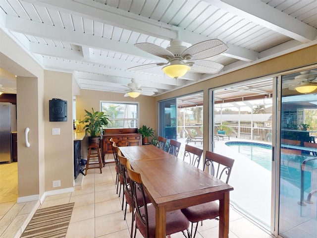 dining space featuring beamed ceiling, ceiling fan, and light tile patterned flooring